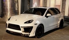 a white sports car parked in front of a building