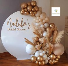 the bridal shower sign is decorated with gold and white balloons, feathers, and balls