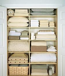 an organized closet with linens, pillows and other items on it's shelves