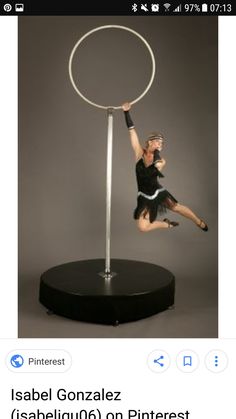 a woman in black shirt and skirt doing aerial acrobatics on a pole