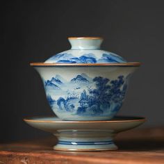 a blue and white bowl sitting on top of a wooden table