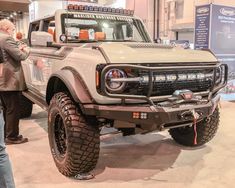 a truck is on display at an auto show with people standing around looking at it