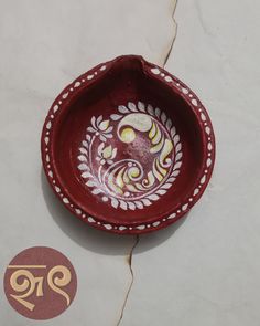 a red and white bowl sitting on top of a table next to a sticker