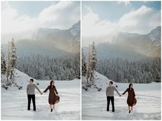 two people holding hands in the snow with mountains in the background and clouds in the sky