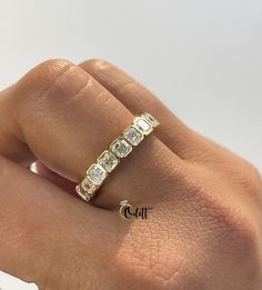 a woman's hand with a diamond ring on top of her finger, showing the band