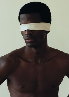 a shirtless man with tape on his face