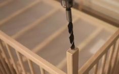 a drill is being used to fix a piece of wood that has been placed in a crib