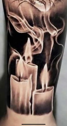 a man's arm with some candles on it