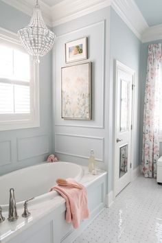 a bathroom with a large tub and chandelier