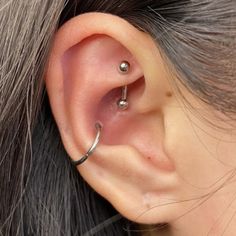 an ear piercing is shown with two balls on it's side and one in the middle