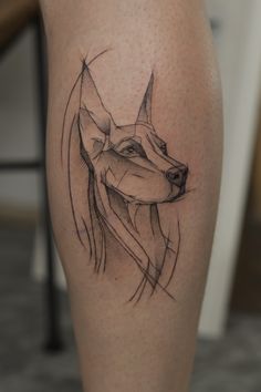 a tattoo on the leg of a person with a dog's head