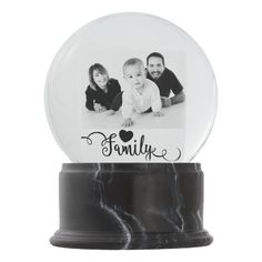 a snow globe with an image of two people and a baby in it that says, create your own family photo