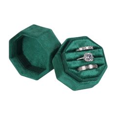 two wedding rings in a green velvet ring box with diamond accents on each band and matching bands