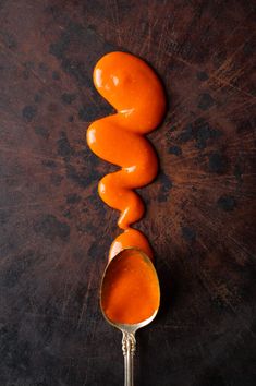 three oranges sitting on top of a spoon next to each other in the shape of a spiral