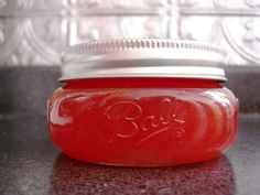 a red jar filled with liquid sitting on top of a counter