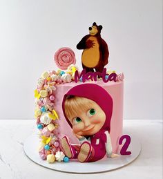 there is a pink cake decorated with an image of masha and the bear on top