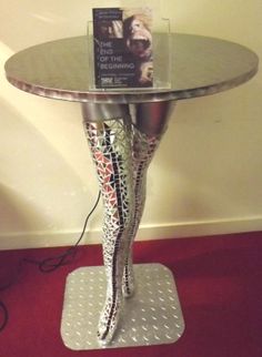 a metal table with a book on top and a red carpet in front of it