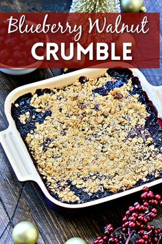 blueberry walnut crumble in a baking dish on a wooden table with berries around it