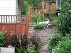 an outdoor garden with flowers and plants growing on the side of it's wall