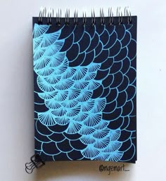 a spiral notebook with blue designs on it