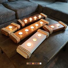 candles are arranged in the shape of boats on a coffee table next to a couch