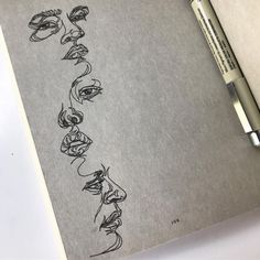 a drawing of several faces on a piece of paper with a marker next to it