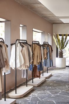 a row of clothing racks with clothes hanging on them