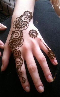 a woman's hand with henna tattoos on it