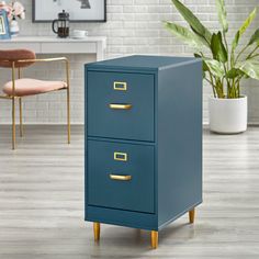 a blue filing cabinet sitting on top of a hard wood floor next to a potted plant