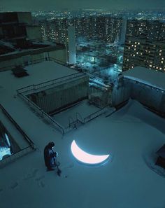 a man standing on top of a snow covered roof next to a crescent shaped moon