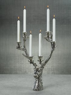 a silver candelabra with five candles in the shape of a deer head