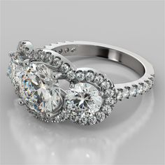 three stone engagement ring with diamond accents on the sides and an oval shaped center surrounded by round brilliant cut diamonds