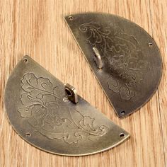 two pieces of metal sitting on top of a wooden table