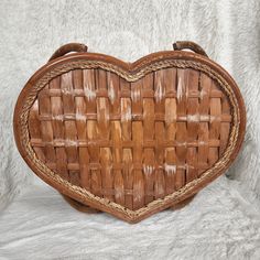 a wooden heart shaped basket sitting on top of a white furnishing background,