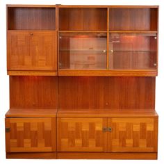 a wooden bookcase with glass doors and drawers