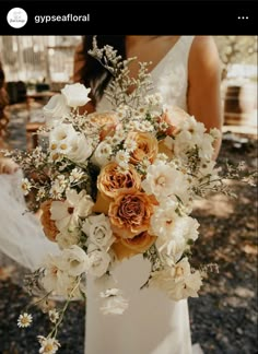 a bride holding a bouquet of white and orange flowers