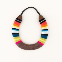 a multicolored necklace is shown on a white surface with a black cord around it