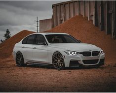 a white car parked in front of a pile of dirt