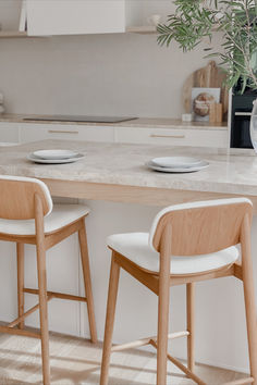 two wooden chairs sitting at a table with plates on it