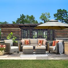 an outdoor living area with patio furniture and umbrella