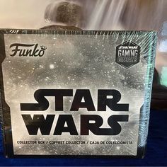 a star wars box sitting on top of a blue tablecloth covered bed with water coming out of it