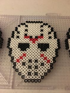 the bead art is designed to look like a skull with red and black eyes