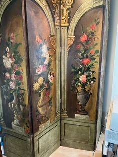 an ornate painted room divider with vases and flowers