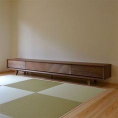 an empty room with a rug and wooden furniture