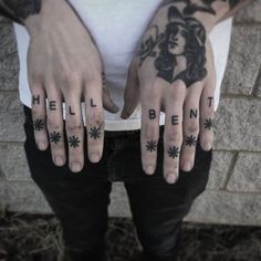 a person with tattoos on their hands holding up two fingers that say hell bente