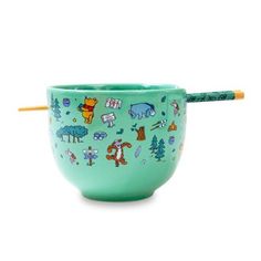 a green bowl with animals on it and a pencil sticking out of the top one