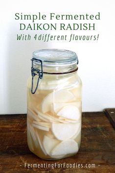 a jar filled with sliced apples sitting on top of a wooden table