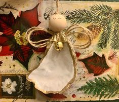 an angel ornament hanging on a wall next to christmas cards and pine cones