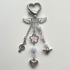 a key chain with an angel charm attached to it's end and charms hanging from the side