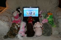 stuffed animals sitting in front of a laptop computer on a white chair with the screen turned on